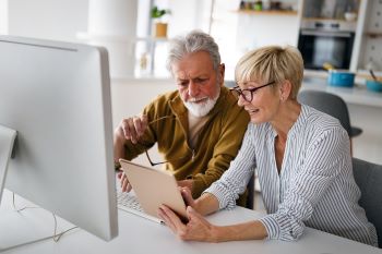 senior-woman-helping-senior-man-to-use-computer-2021-08-31-11-02-27-utc 350